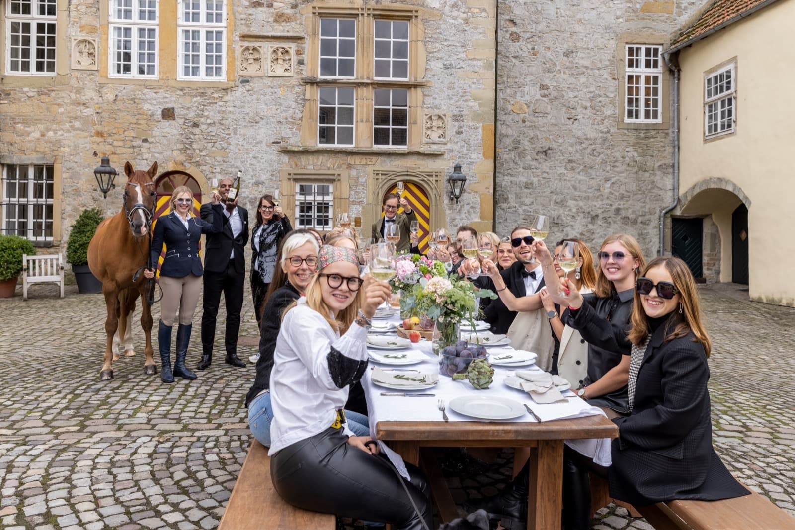 Das Team von Optik Peter Meyer an einer langen Tafel im Schlosshof